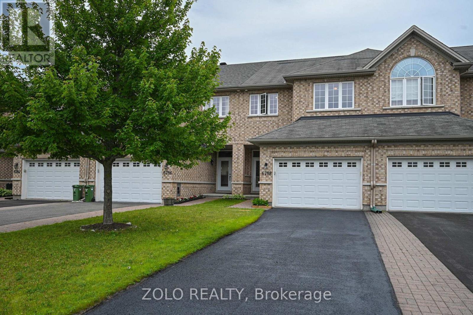 Front brick exterior and paved driveway.