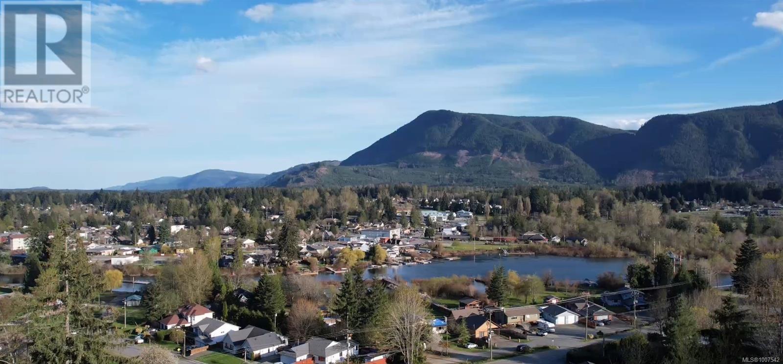 Aerial view of property's location with a water and mountain view and a heavily wooded area