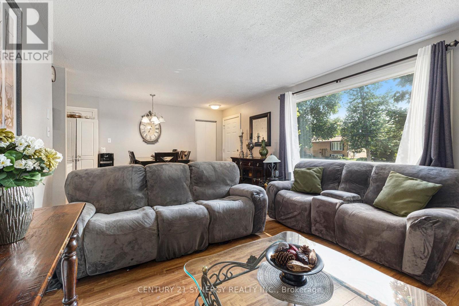 Living room with large bay window, open to dining.