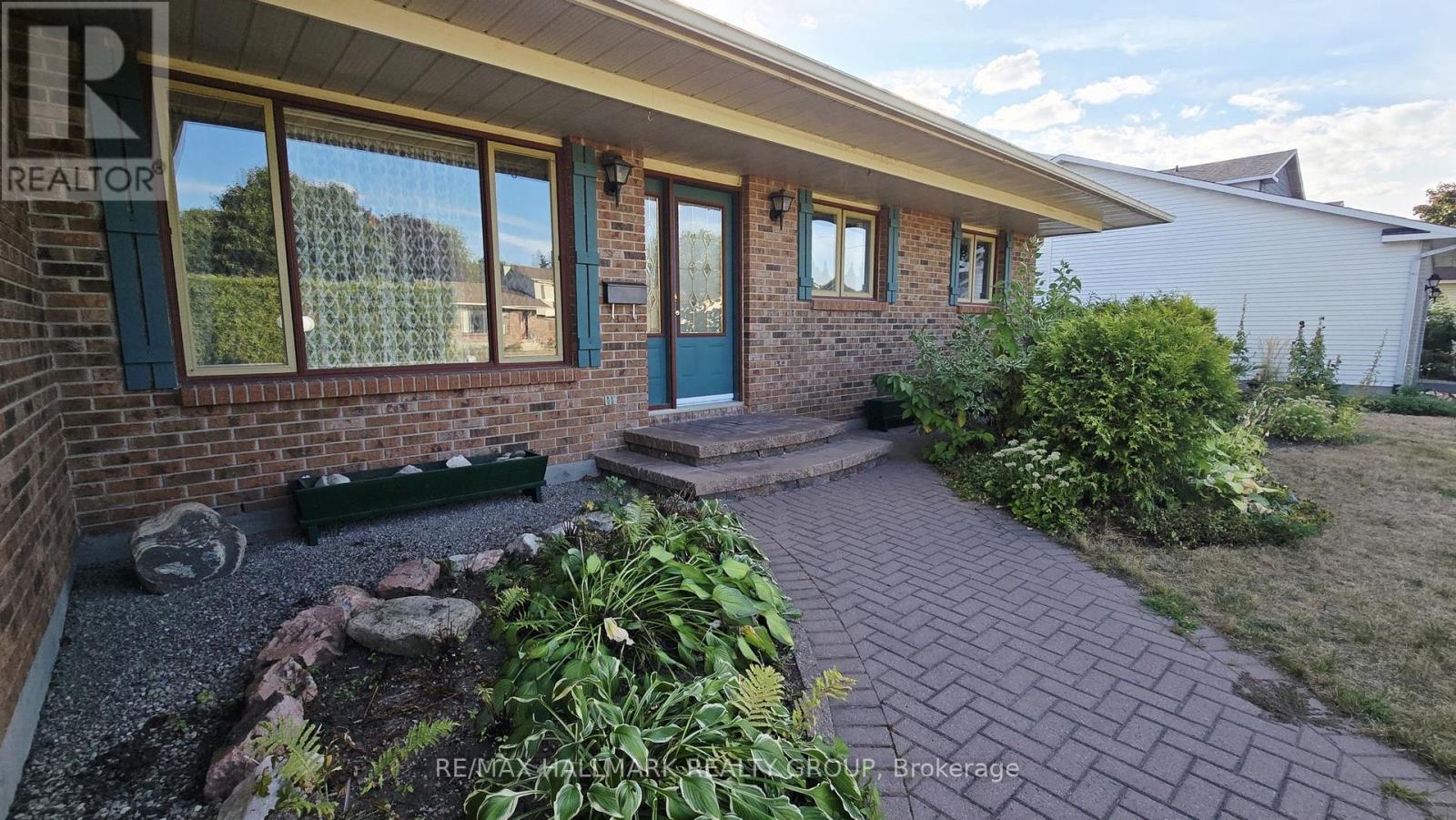 Inviting interlock front walkway & step w/gardens!