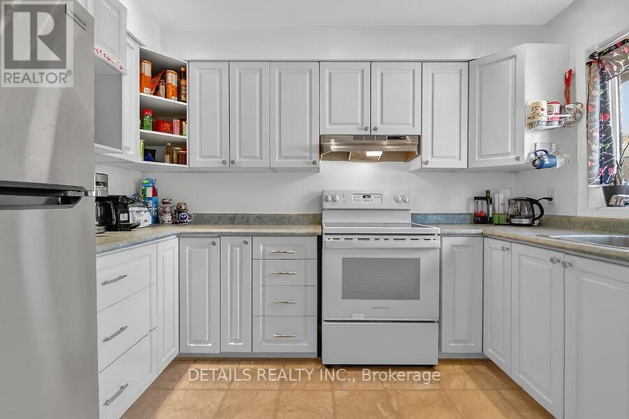 SS fridge w/ bright cupboards.