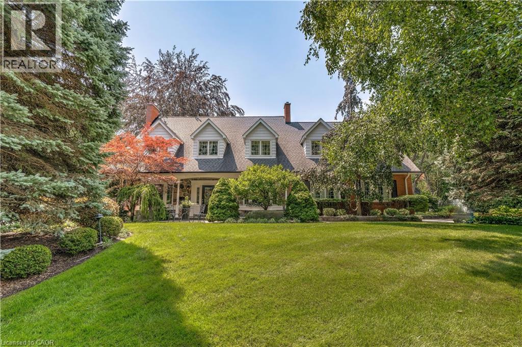 Cape cod-style house featuring a chimney, a front lawn, and a porch