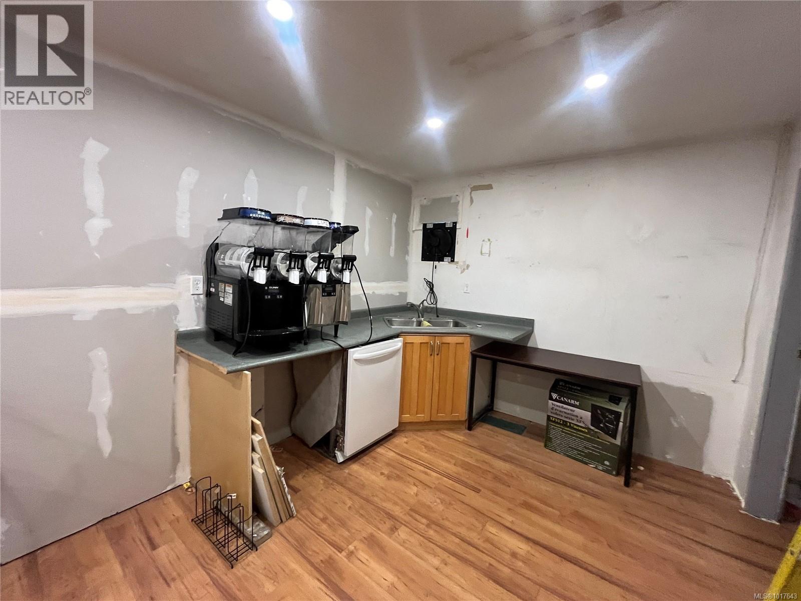Kitchen featuring white dishwasher, light wood-style flooring, and a sink