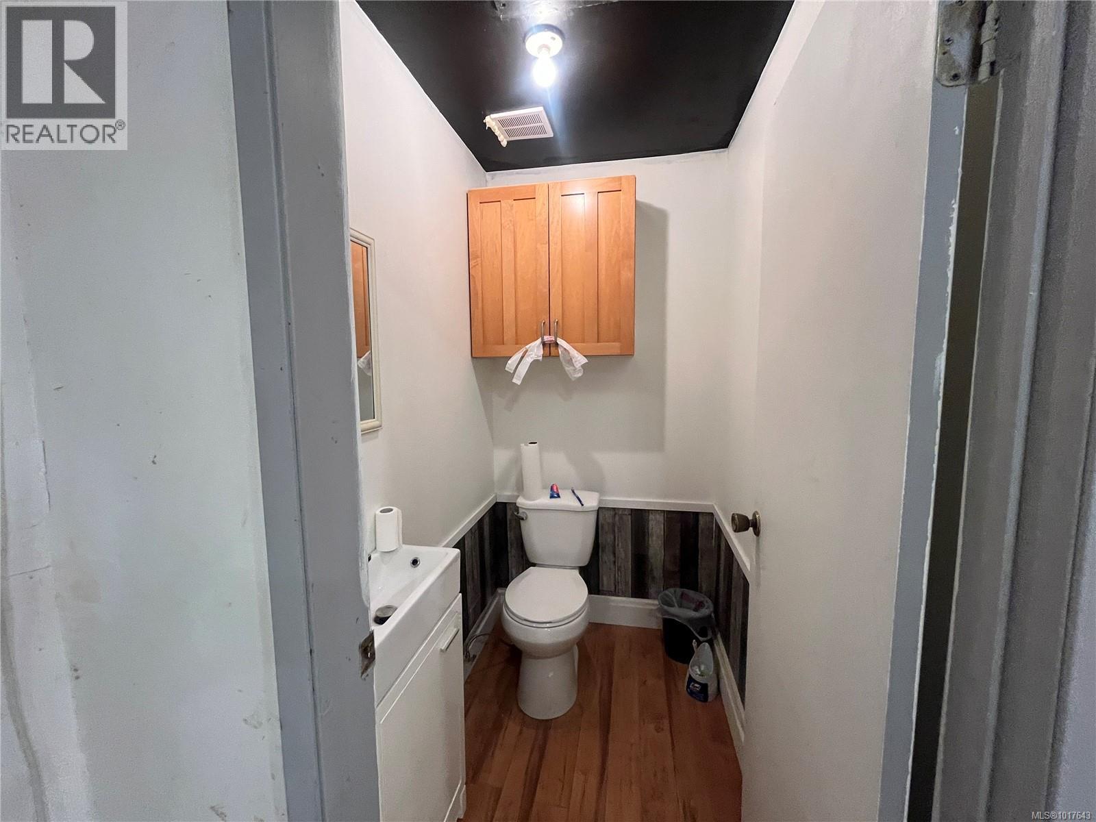 Bathroom with toilet, wood finished floors, and visible vents
