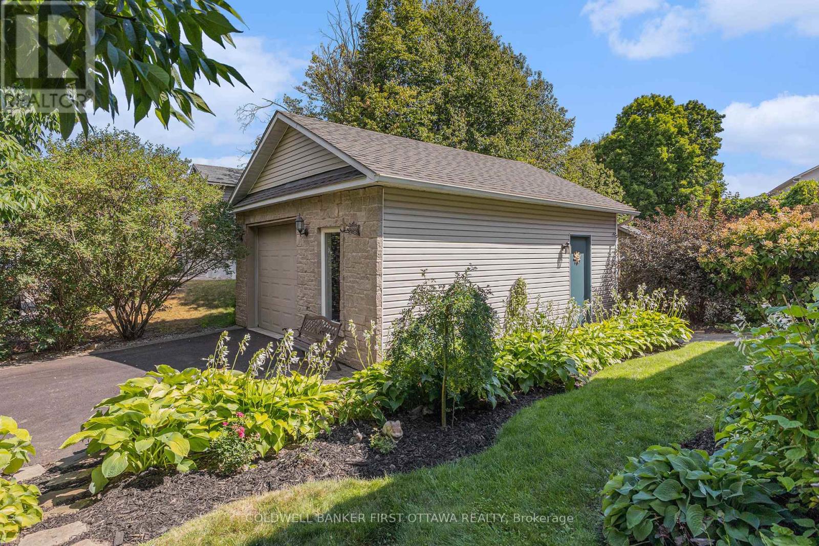 Summer view of detached garage-workshop with hydro