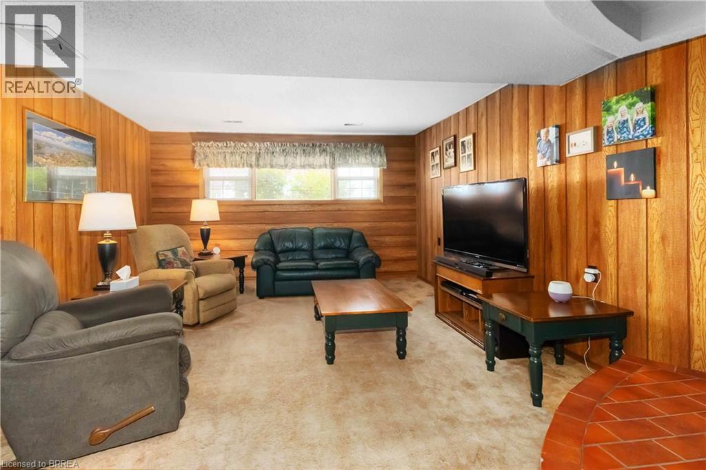 Carpeted living room featuring wooden walls and a textured ceiling