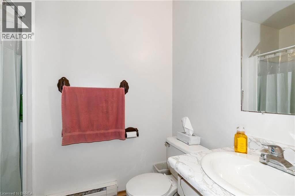 Bathroom featuring a stall shower, vanity, and baseboard heating