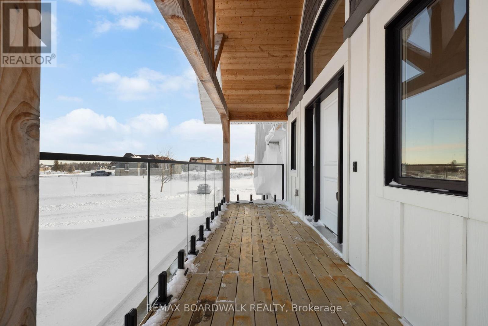 Raised veranda w/glass railing overlooking front.