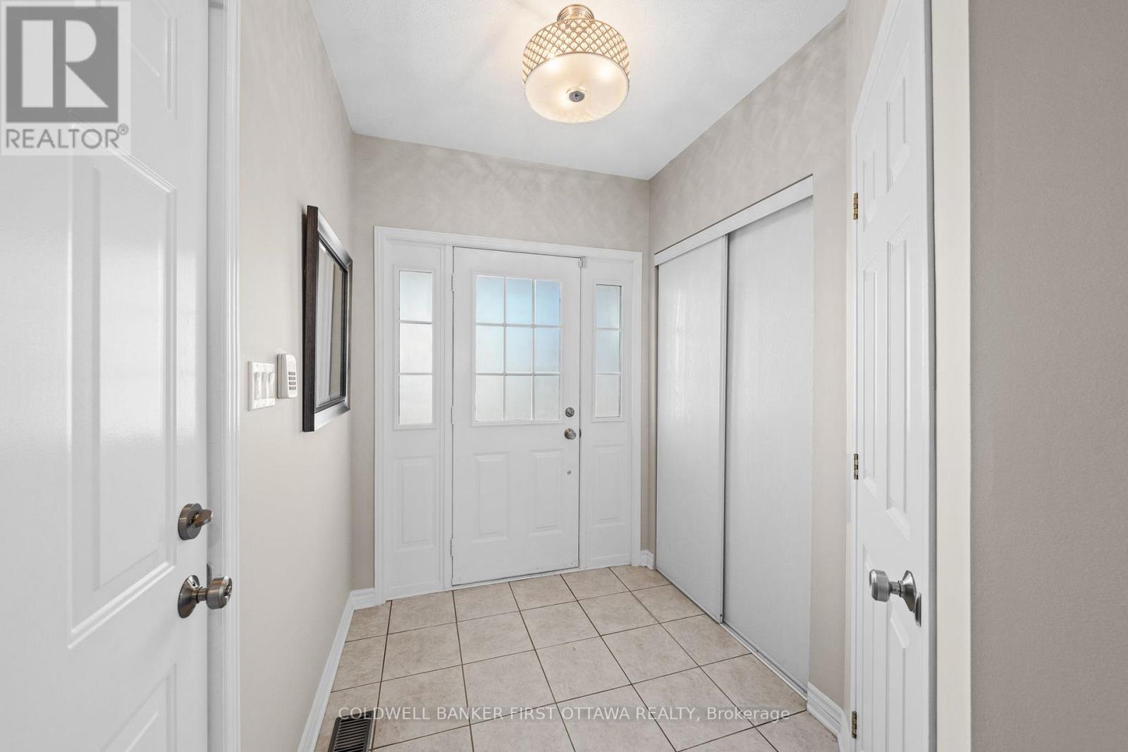 Welcoming, tiled front foyer w closet space.