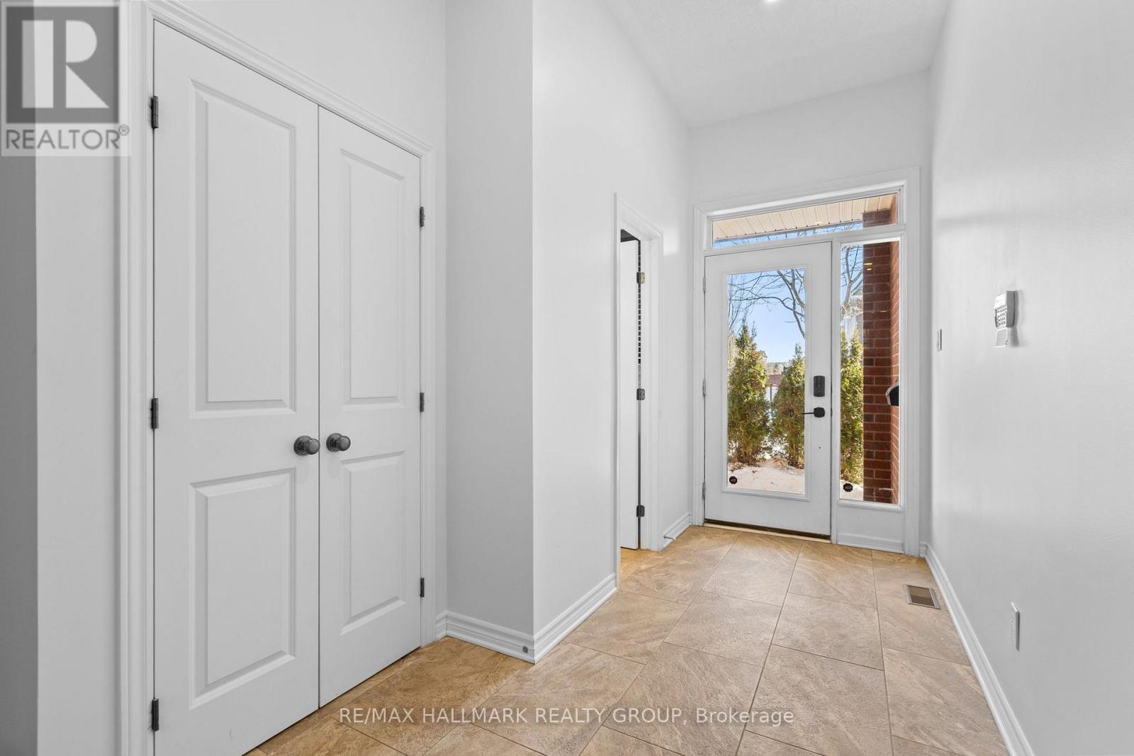 Bright foyer with tile floor and closet