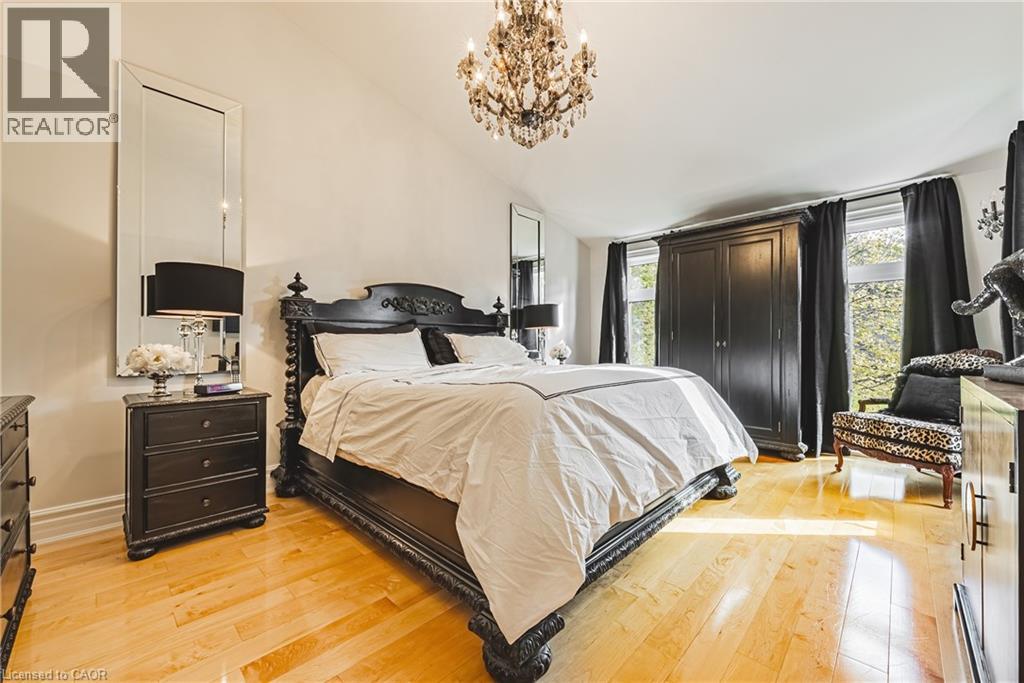 Bedroom featuring lofted ceiling, a chandelier, and light wood-type flooring