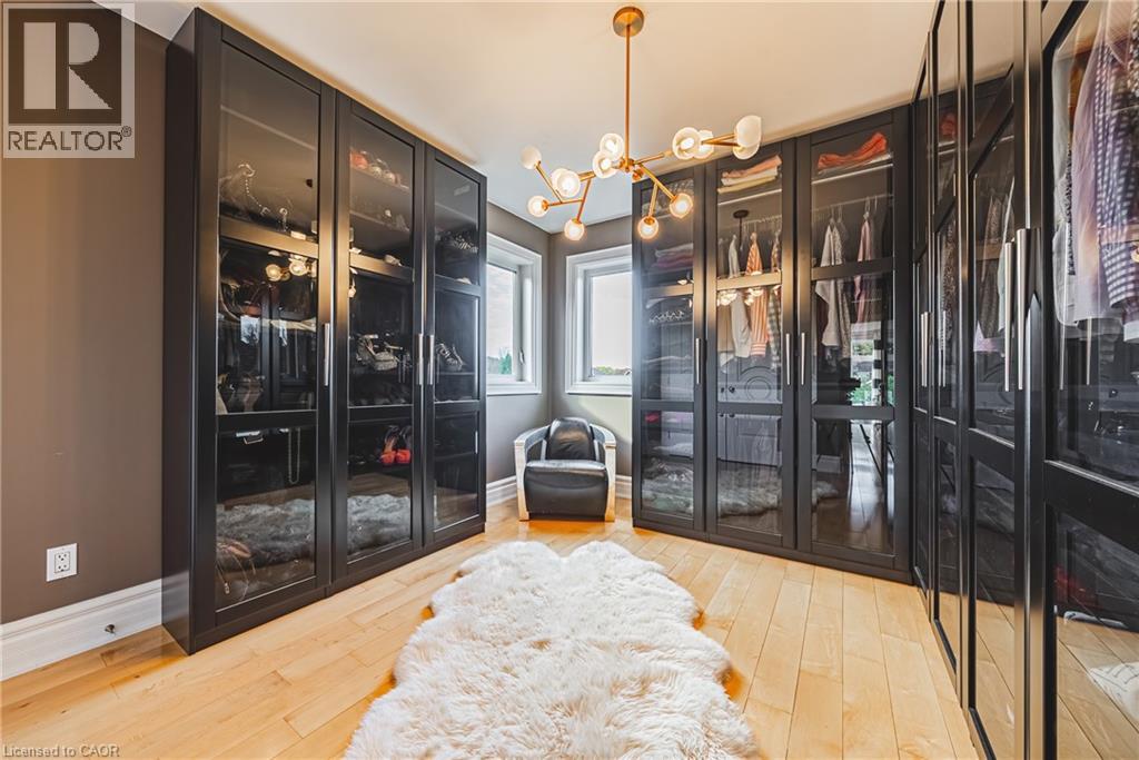 Spacious closet with a chandelier and light wood-style floors