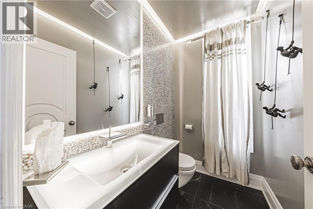 Full bathroom featuring curtained shower, dark tile patterned flooring, and vanity