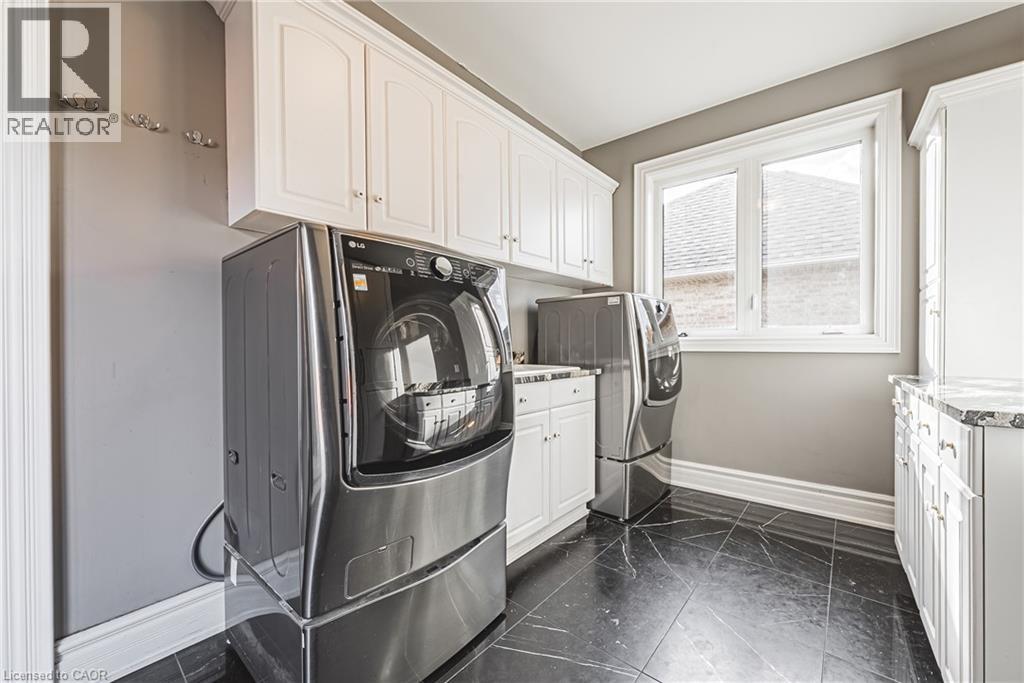 Washroom with washer and clothes dryer and cabinet space
