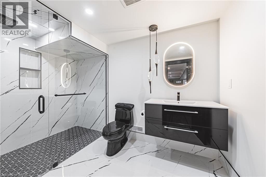 Bathroom featuring vanity, a marble finish shower, recessed lighting, and marble finish floors