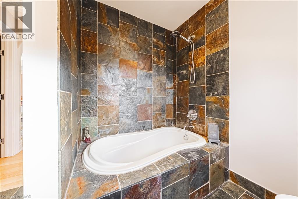 Bathroom featuring tiled shower / bath and baseboards