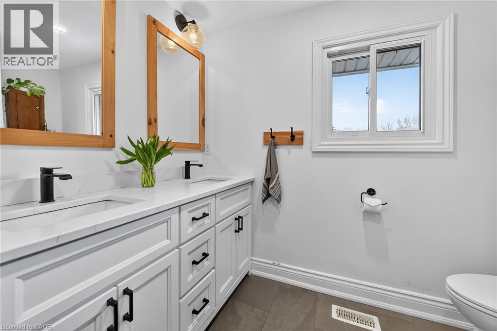 Full bathroom featuring double vanity and toilet