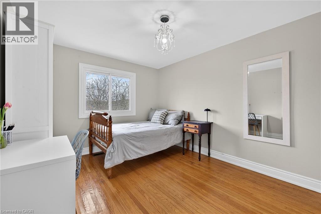 Bedroom featuring light wood-style floors and suspended lighting