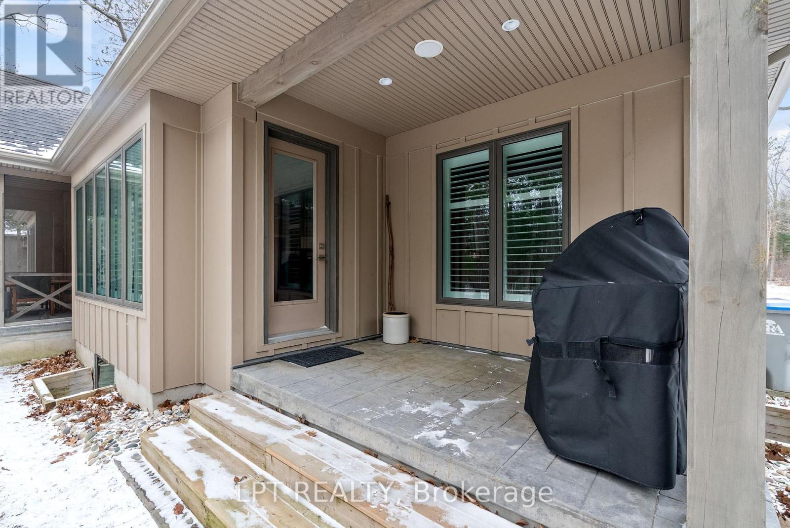 Covered porch off the kitchen for barbecuing.
