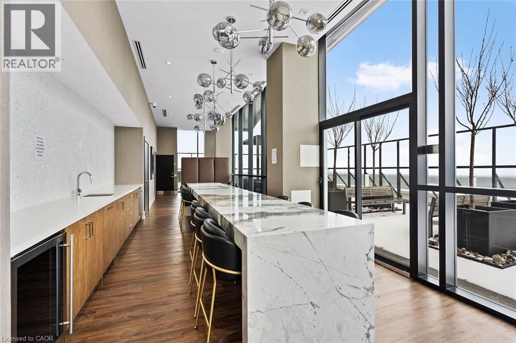 Kitchen with modern cabinets, a breakfast bar area, light stone countertops, beverage cooler, and wood finish cabinetry