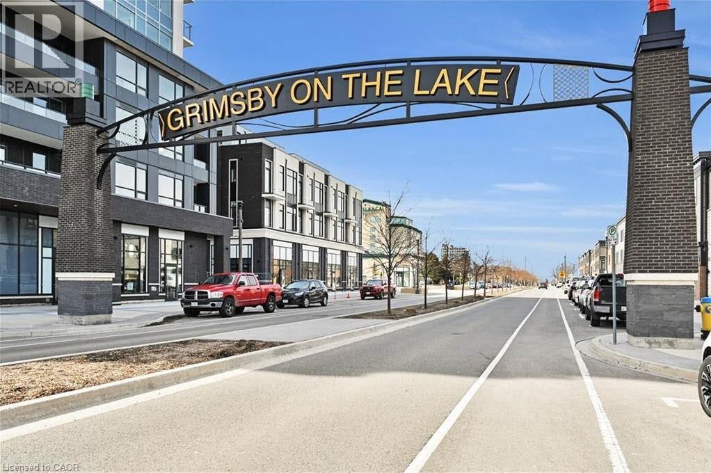 View of asphalt road featuring curbs, sidewalks, and street lights