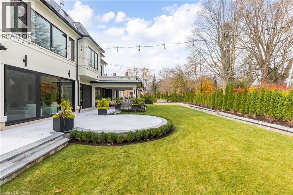 View of grassy yard featuring a balcony and a patio area