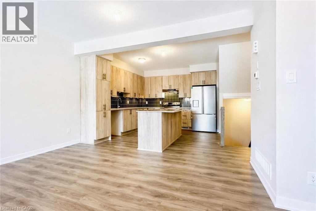 Kitchen with a center island, stainless steel appliances, light wood finished floors, light wood finish cabinets, and light countertops