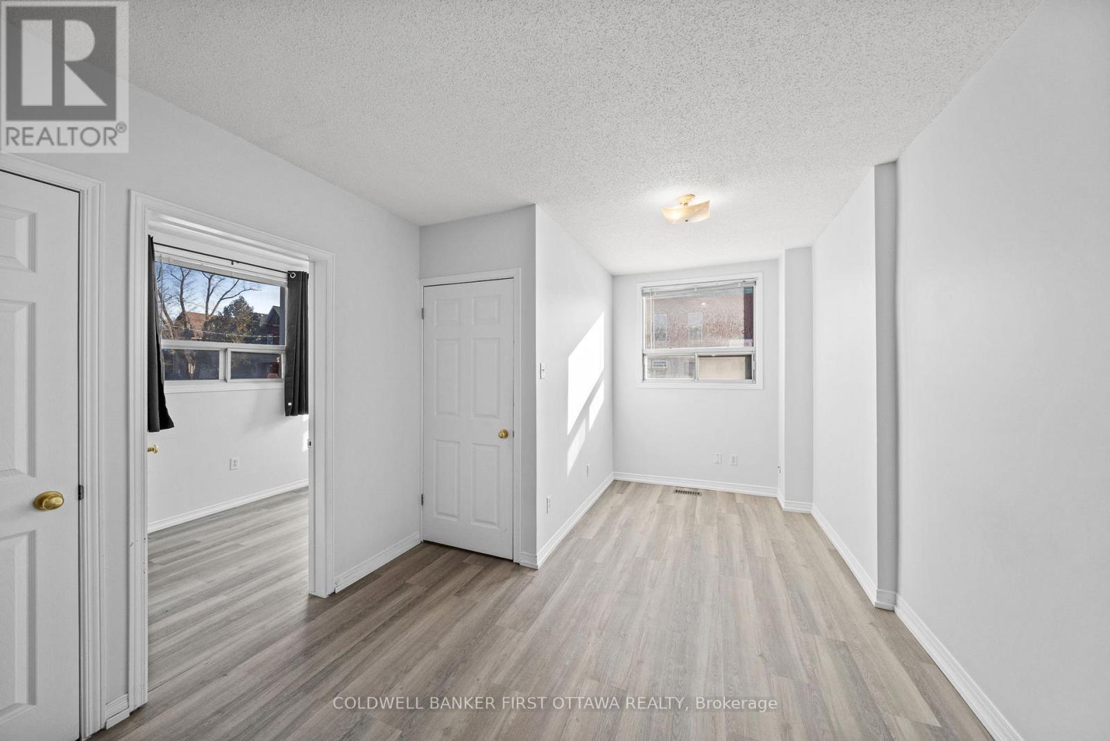 Living room w bright window & vinyl flooring.