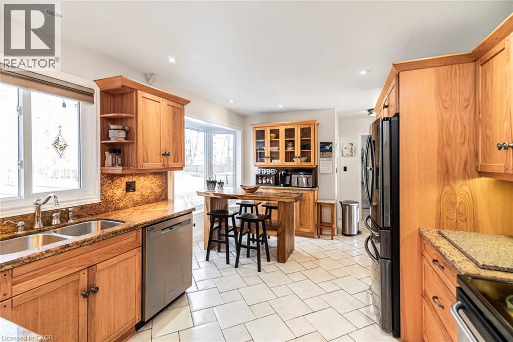 Kitchen with light stone countertops, brown cabinetry, appliances with stainless steel finishes, tasteful backsplash, and open shelves