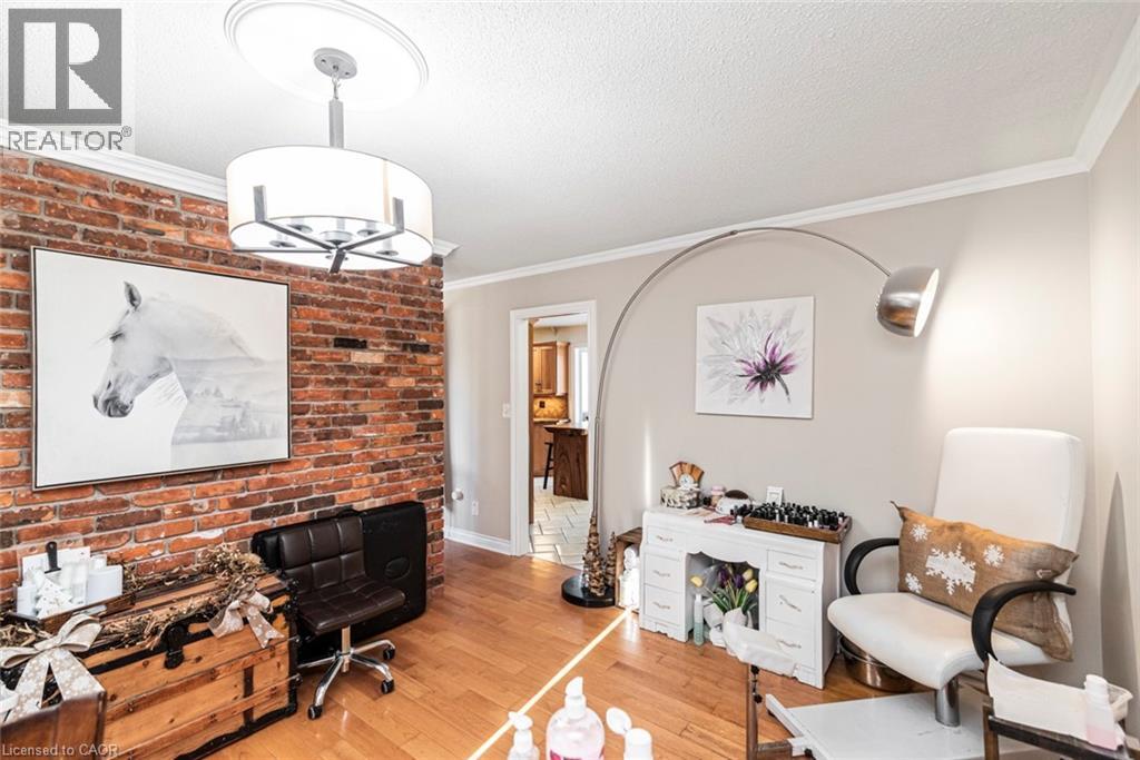 Office featuring ornamental molding, wood-type flooring, a textured ceiling, brick wall, and a chandelier
