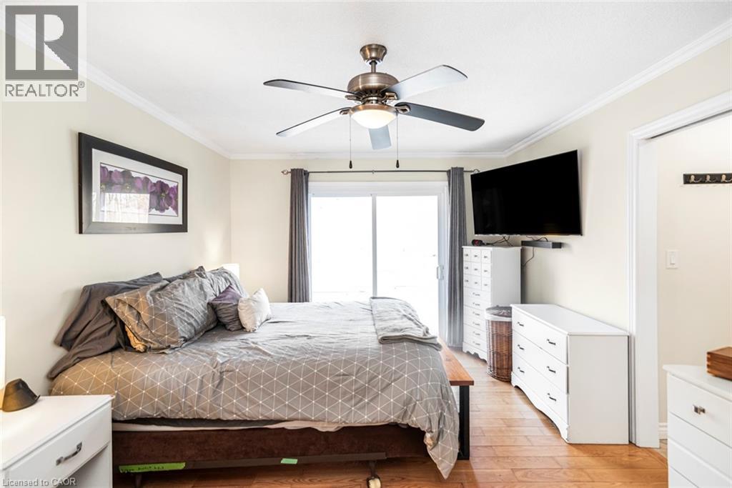 Bedroom featuring crown molding, a ceiling fan, light wood-style flooring, and access to exterior