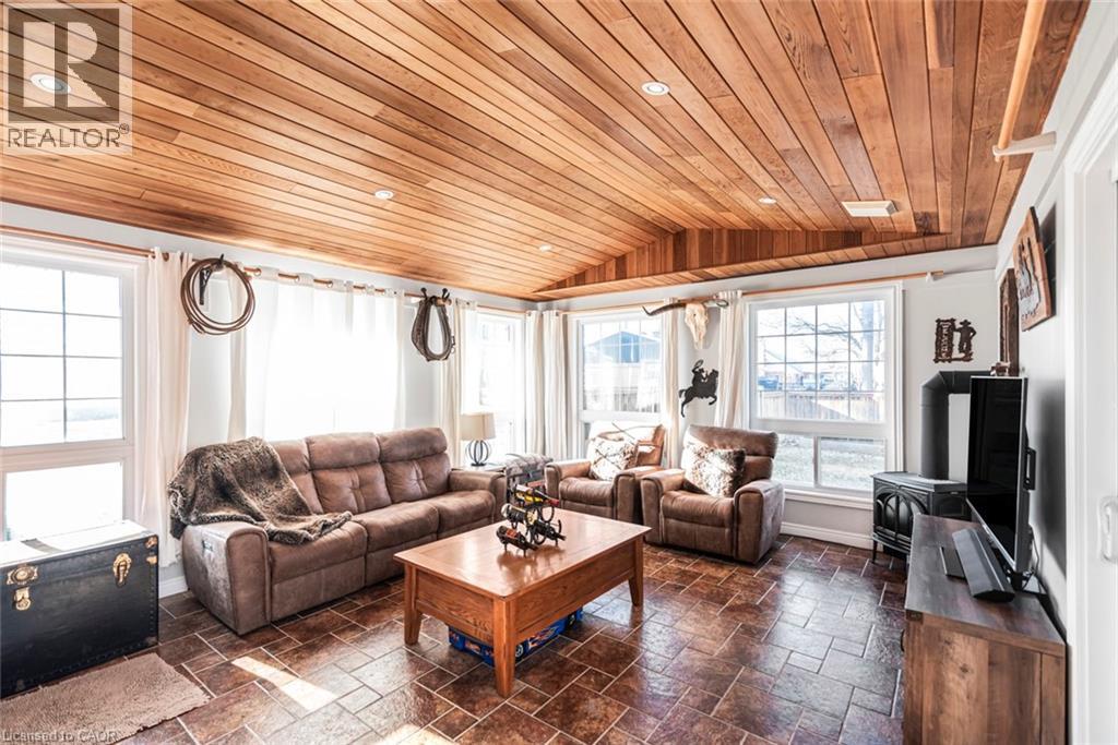 Living area with lofted ceiling, wood ceiling, stone tile flooring, healthy amount of natural light, and recessed lighting