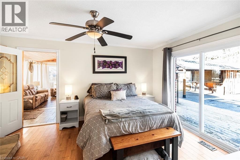 Bedroom featuring light wood-type flooring, access to exterior, crown molding, and ceiling fan
