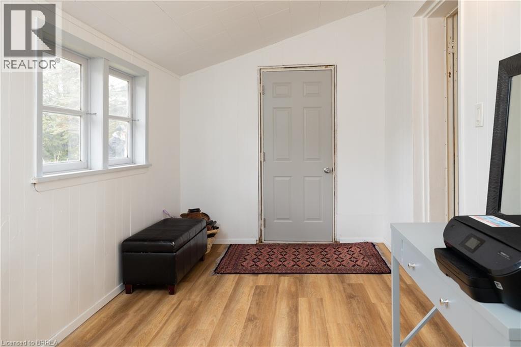 Entryway with light wood-type flooring, lofted ceiling, and wooden walls