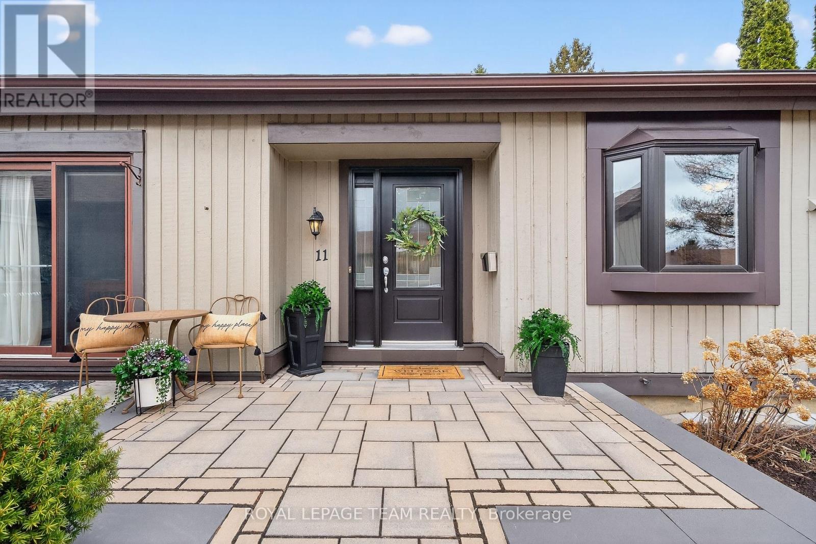Front door with stone patio and sitting area