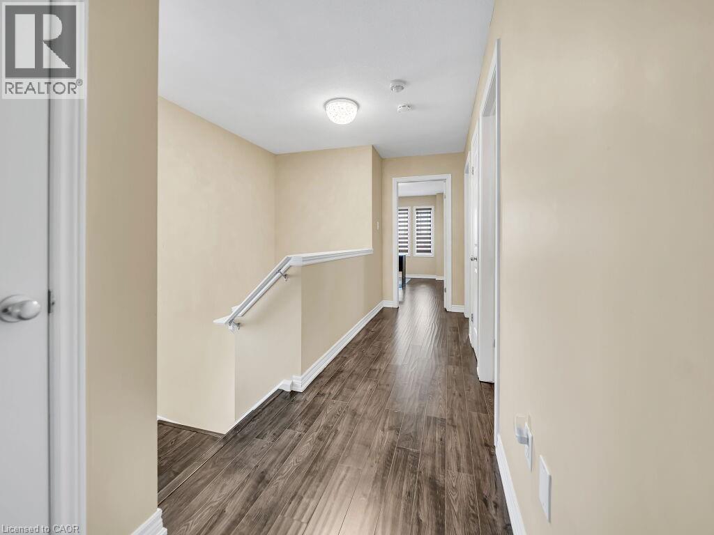Hallway featuring an upstairs landing and dark wood-style floors