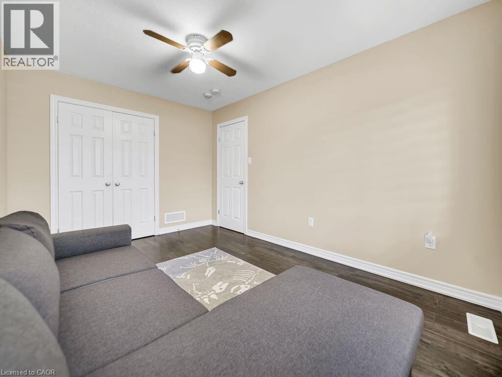 Living room featuring dark wood-style flooring and a ceiling fan