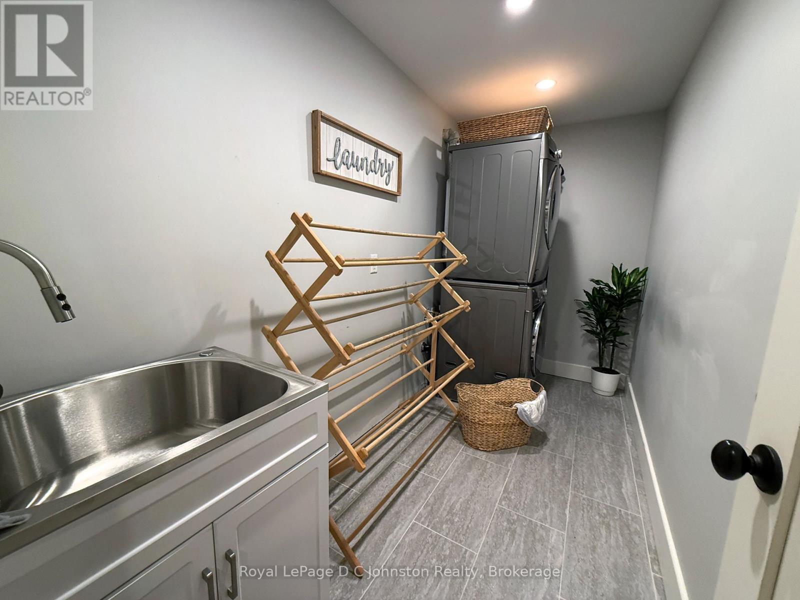 Large Laundry room with sink, stacked washer/dryer