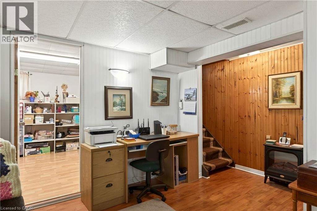 Office area with light wood-style flooring and a paneled ceiling