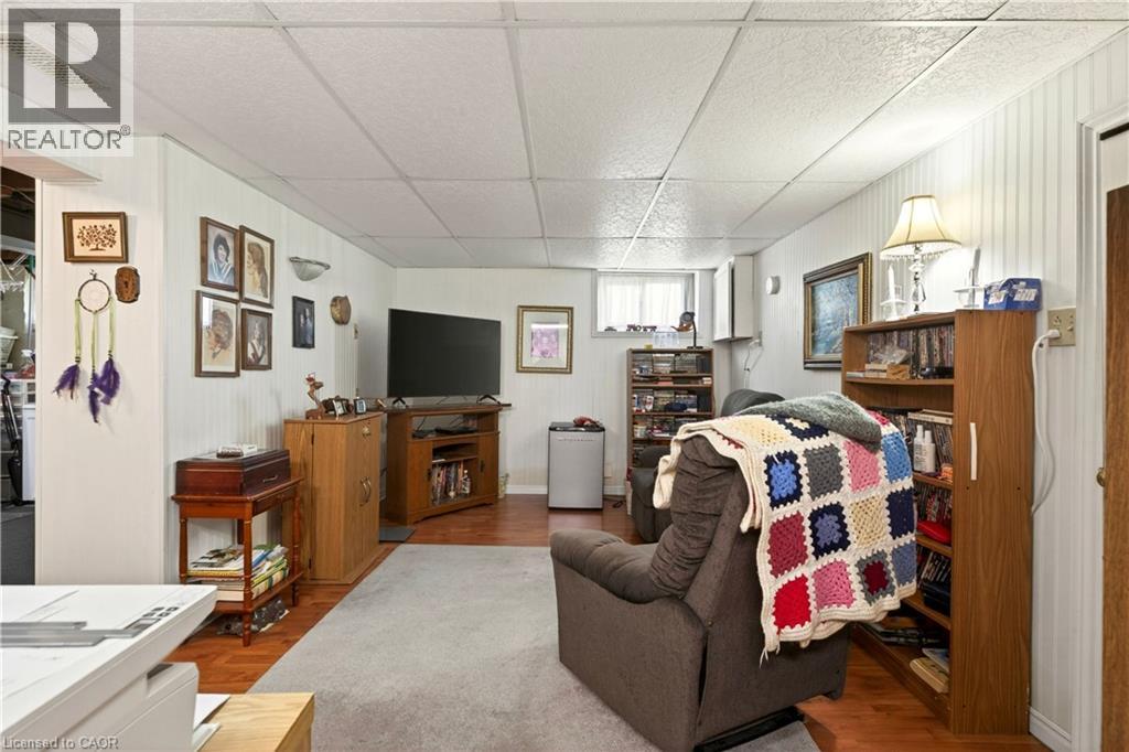 Living area with a paneled ceiling, wood walls, and wood finished floors