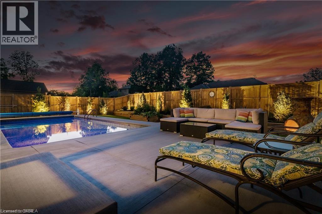 Pool at dusk with a fenced backyard, outdoor lounge area, and a patio area