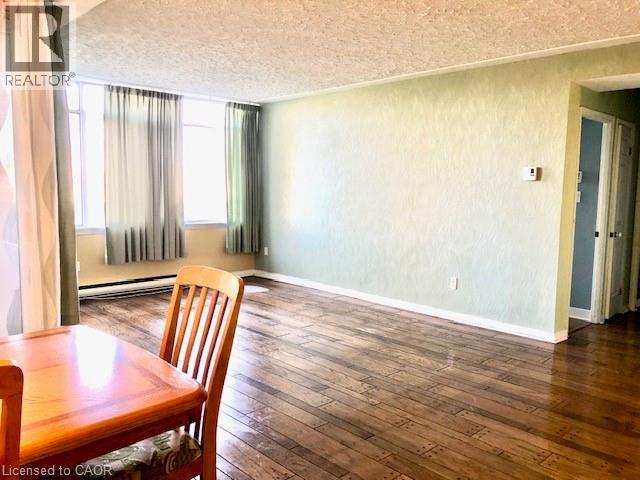 Dining area with dark wood finished floors and a baseboard radiator