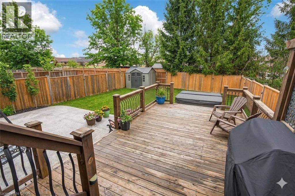 Deck with a storage shed, a fenced backyard, and a grill