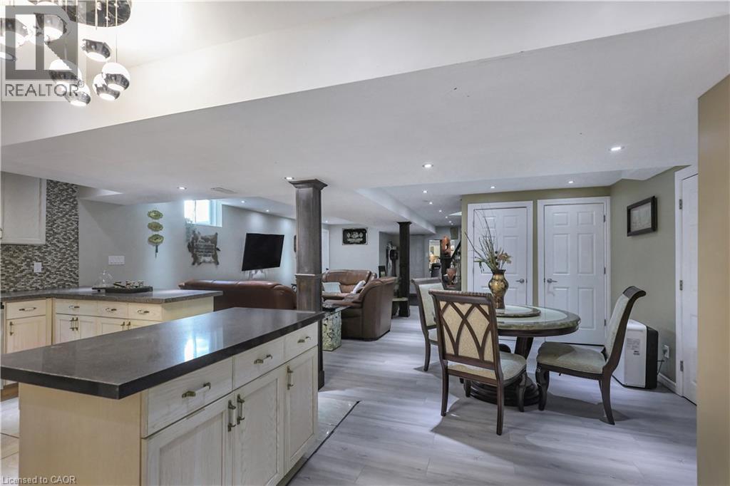 Kitchen featuring a kitchen island, open floor plan, dark countertops, tasteful backsplash, and light wood-type flooring