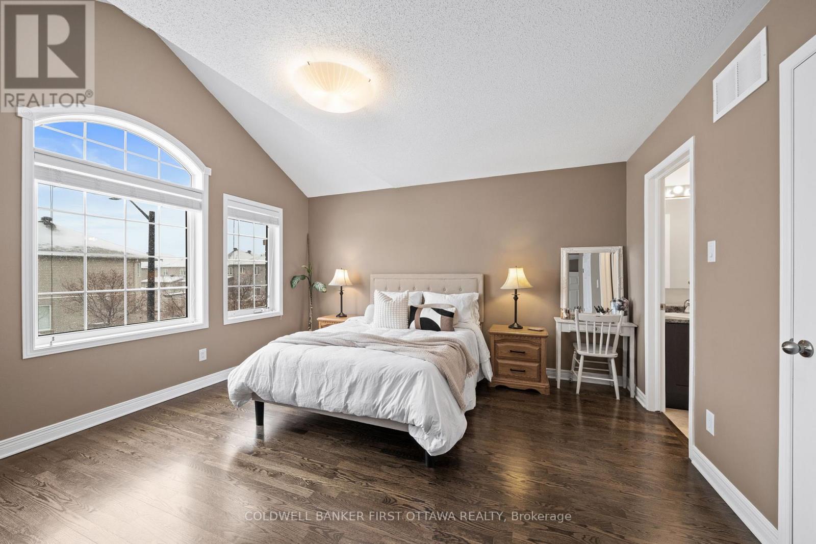 Primary bedroom w 3 huge windows & vaulted ceiling