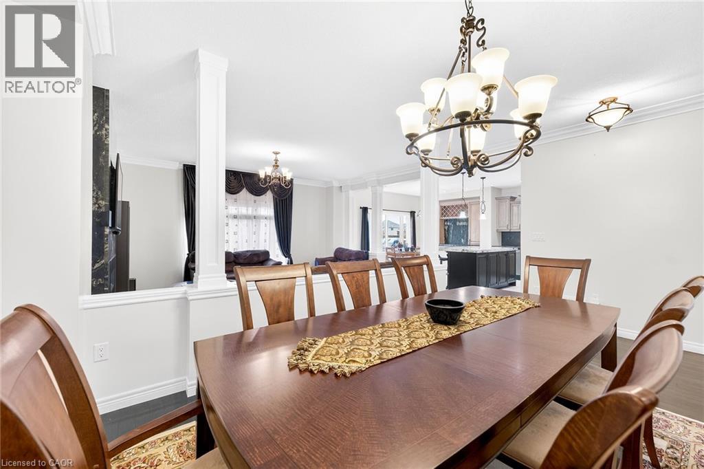 Dining room with suspended lighting, crown molding, and wood finished floors
