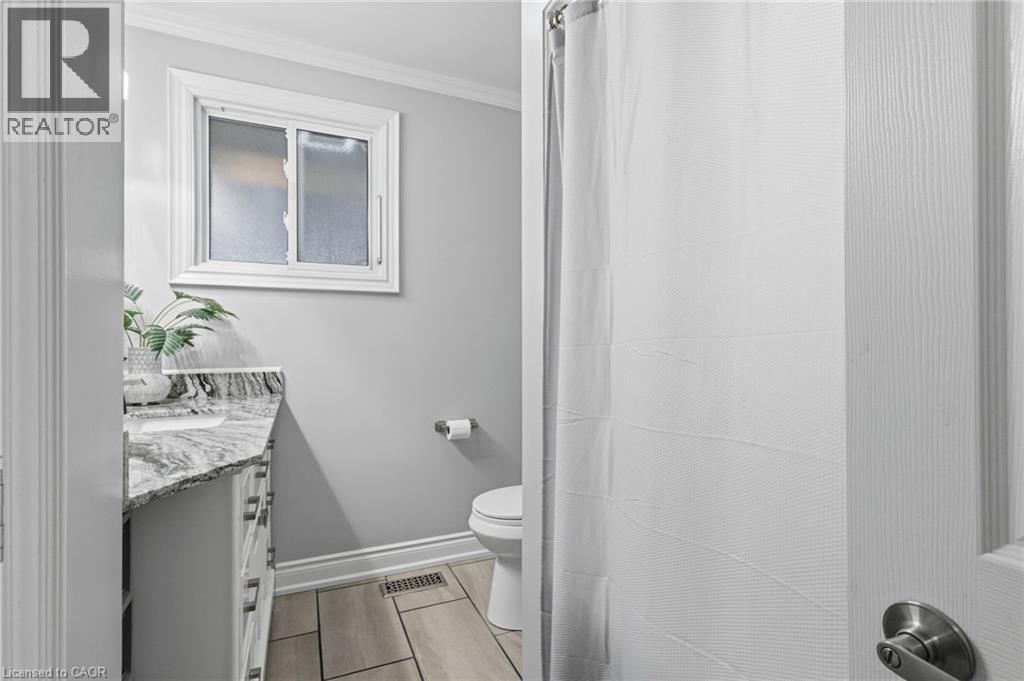 Bathroom with vanity, a shower with shower curtain, crown molding, and wood finish floors