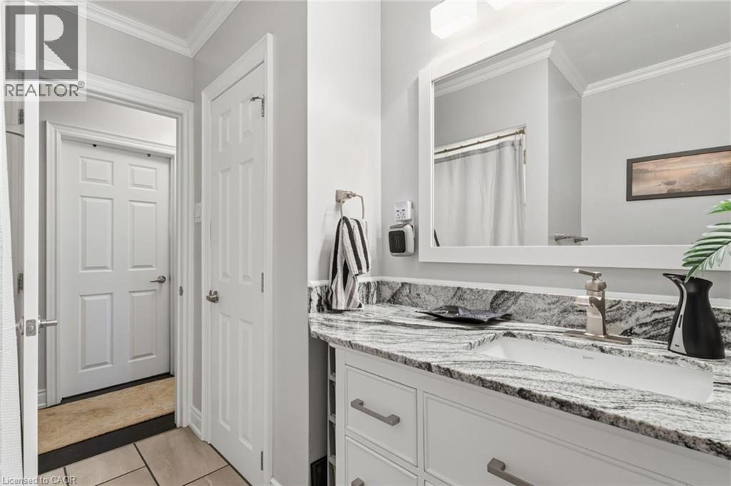 Bathroom with crown molding, vanity, a shower with shower curtain, and light tile patterned floors