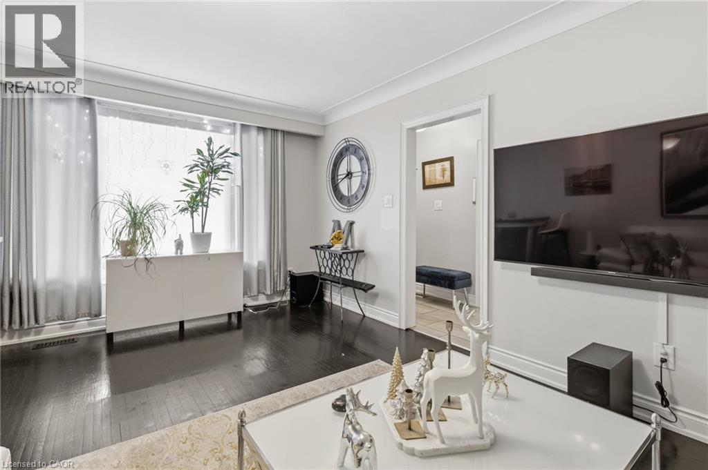 Living area featuring dark wood-style floors and crown molding