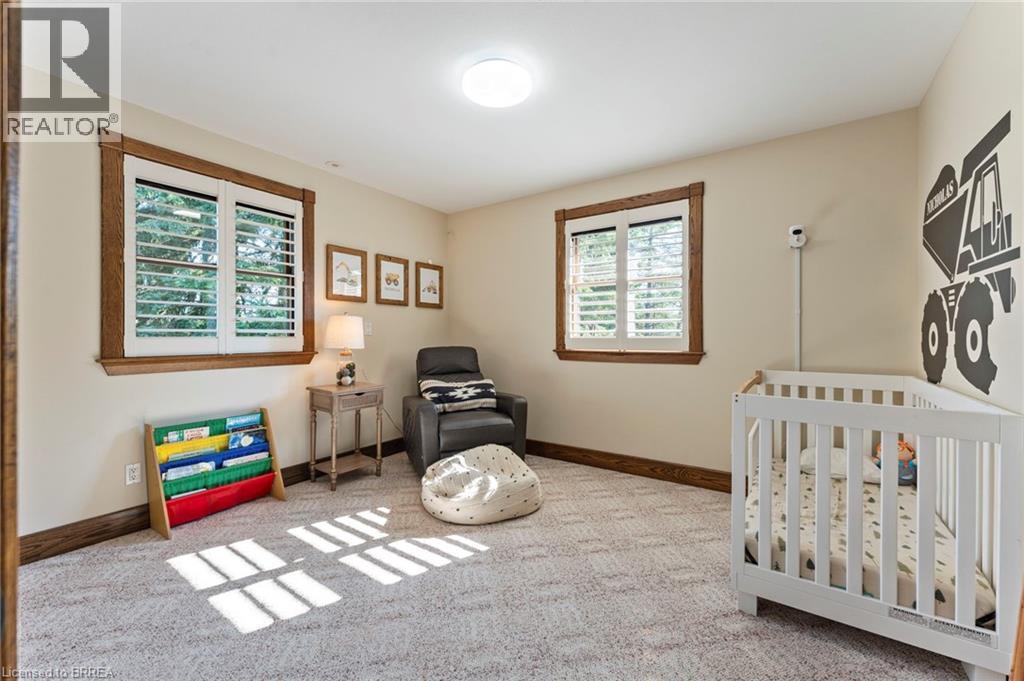 Bedroom featuring a nursery area and light carpet